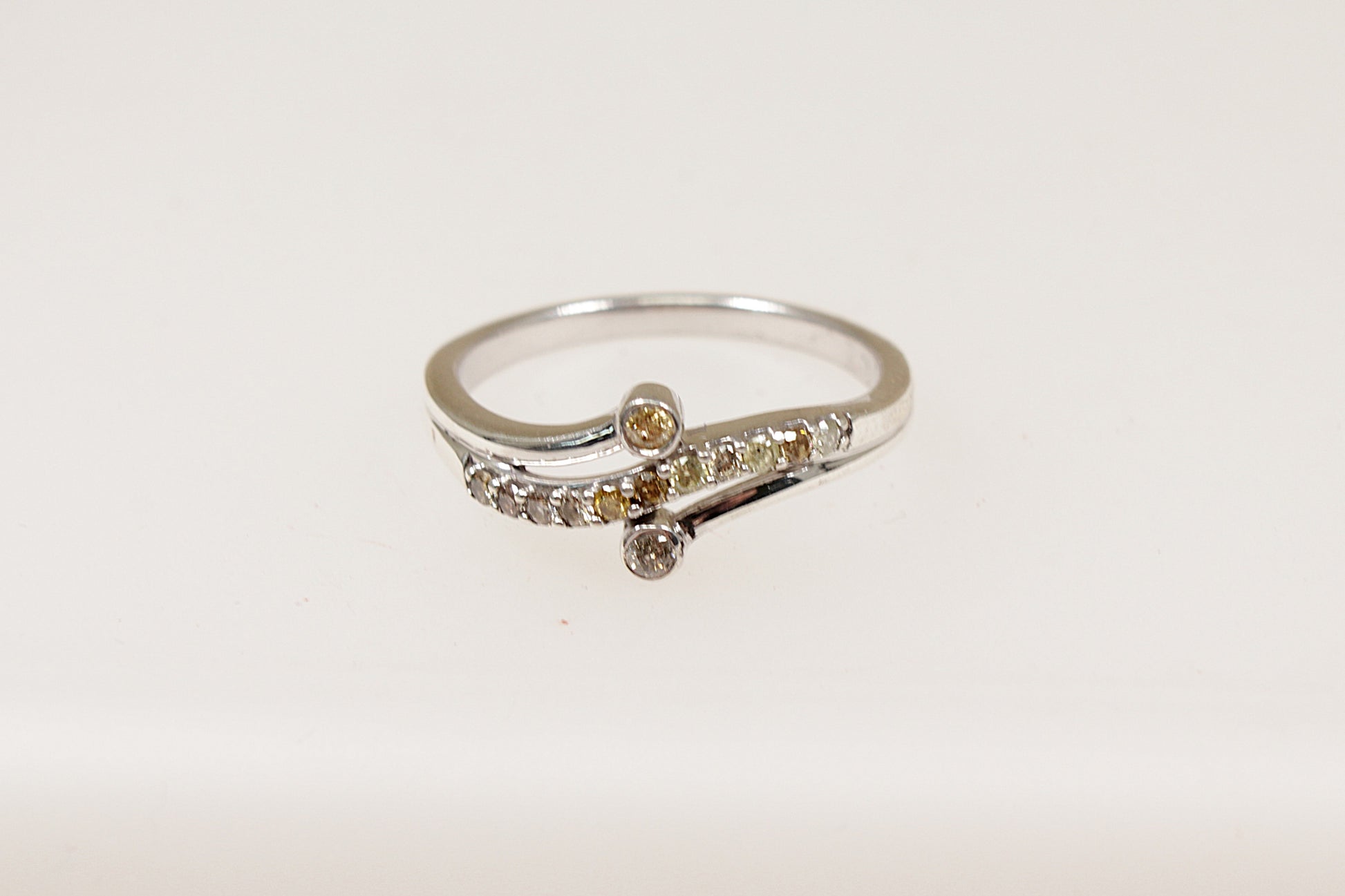 The main feature of this beautiful Silver ring is a wavy band design set with shimmering Diamonds, adding a sense of movement and flow to the piece. Two additional diamonds are set on each side of the band framing the wavy design and enhancing the overall sparkle. UK finger size S.