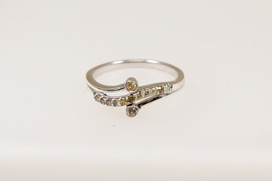 The main feature of this beautiful Silver ring is a wavy band design set with shimmering Diamonds, adding a sense of movement and flow to the piece. Two additional diamonds are set on each side of the band framing the wavy design and enhancing the overall sparkle. UK finger size S.