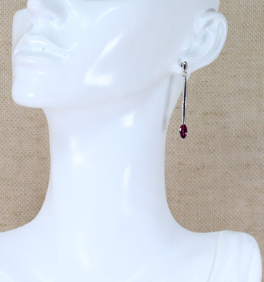 A pair of silver drop earrings with marquise cut cubic zirconia gemstones on a mannequin head.