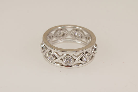 Silver eternity ring with cubic zirconia diamond simulant accents on a light gray background