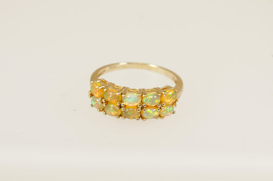 A striking and colourful piece, this Sterling Silver ring showcases ten round cabochon Fire Jelly Opals, arranged in two elegant rows of five stones each. The opals are claw set side by side, forming a luminous band of shifting colour. UK finger size O.