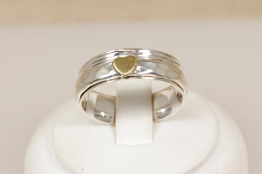 Silver ring with a gold heart-shaped inset on a white background