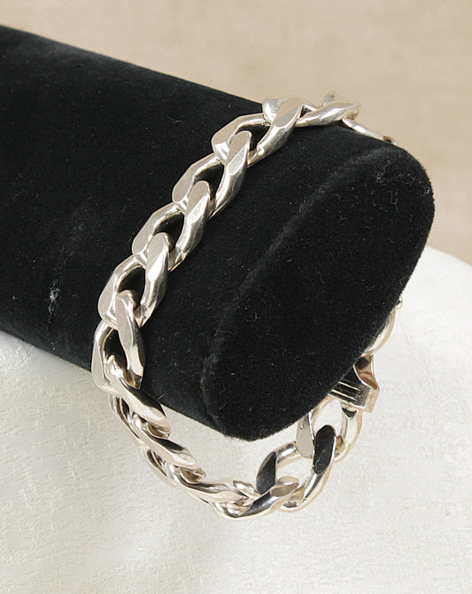 Heavy Silver flat curb link chain bracelet on a black velvet stand with a white background