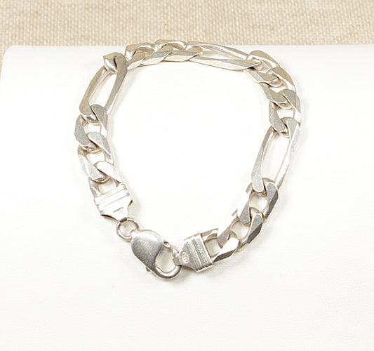 A silver Italian Figaro bracelet with a robust lobster clasp, displayed on a white surface.