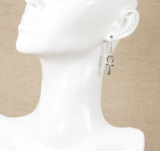 A pair of silver drop earrings with a key of life cross displayed on a mannequin head.