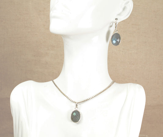 Necklace and earrings with labradorite gemstones on a mannequin against a beige background