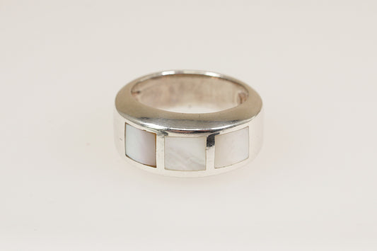 A vintage sterling silver band ring with mother of pearl inlays, viewed from the top with a white background.