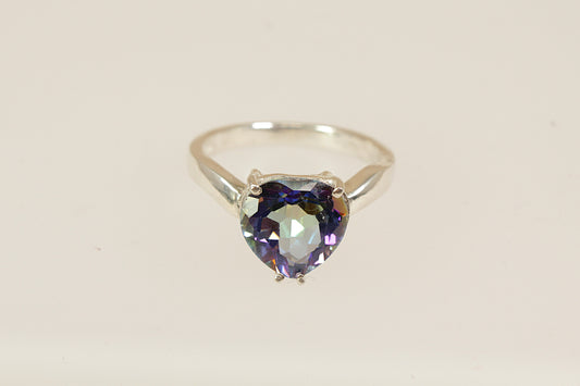 A lovely and eye-catching sterling silver statement ring featuring a dazzling heart-shaped mystic blue topaz as the centrepiece. The stone shimmers with enchanting iridescent tones, ranging from deep blue to flashes of green and violet, depending on the light. UK finger sie P.