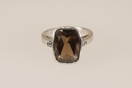 Silver ring with a smoky quartz gemstone on a beige background
