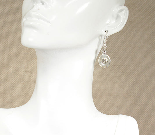 A pair of silver topaz drop earrings displayed on a mannequin head.
