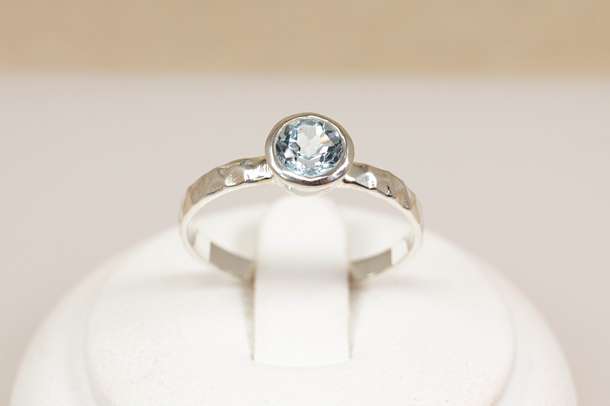Silver ring with a blue gemstone on a white background