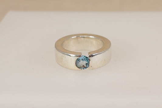 Silver statement ring with a blue topaz gemstone on a white background
