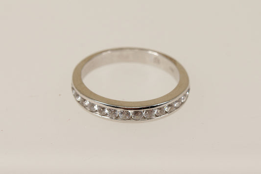 A silver white topaz half eternity ring with channel setting, displayed against a white background.