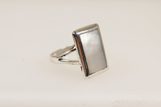 A silver ring with a rectangular mother of pearl inlay against a white background.