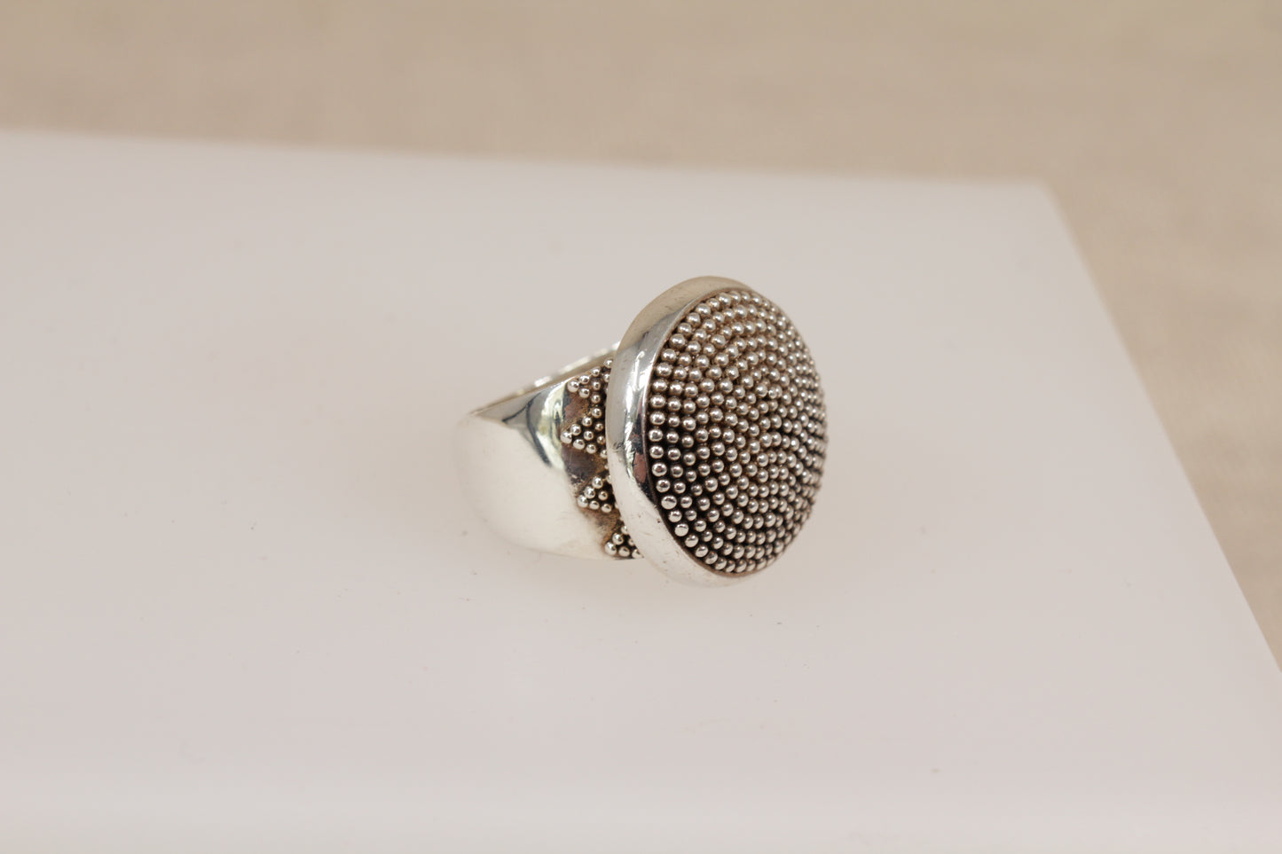 Silver Suarti ring with textured design on a white surface