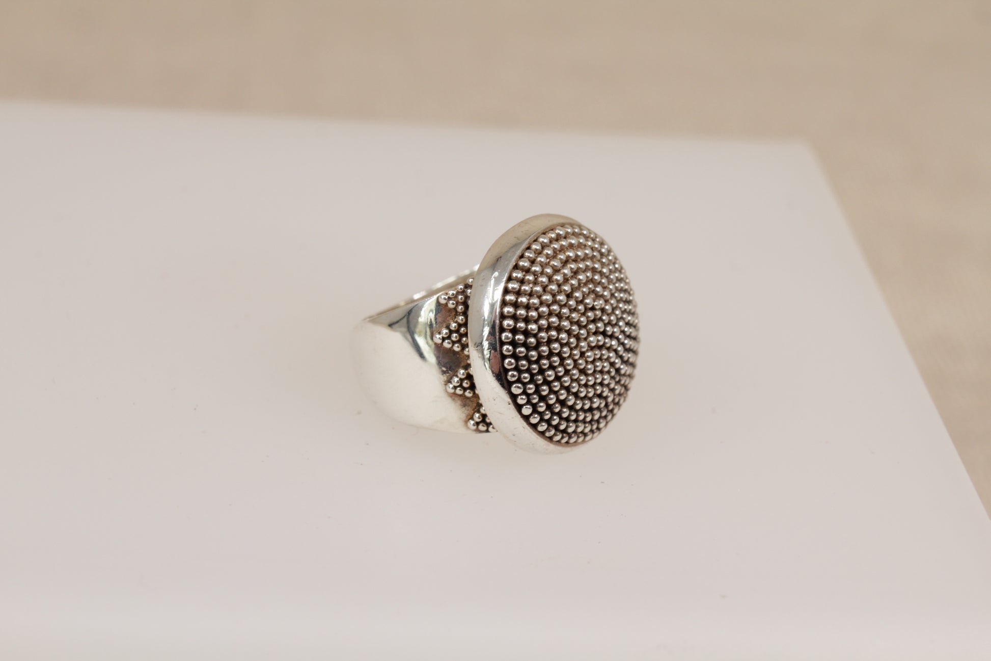 Silver Suarti ring with textured design on a white surface