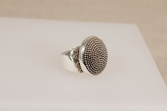 Silver Suarti ring with textured design on a white surface