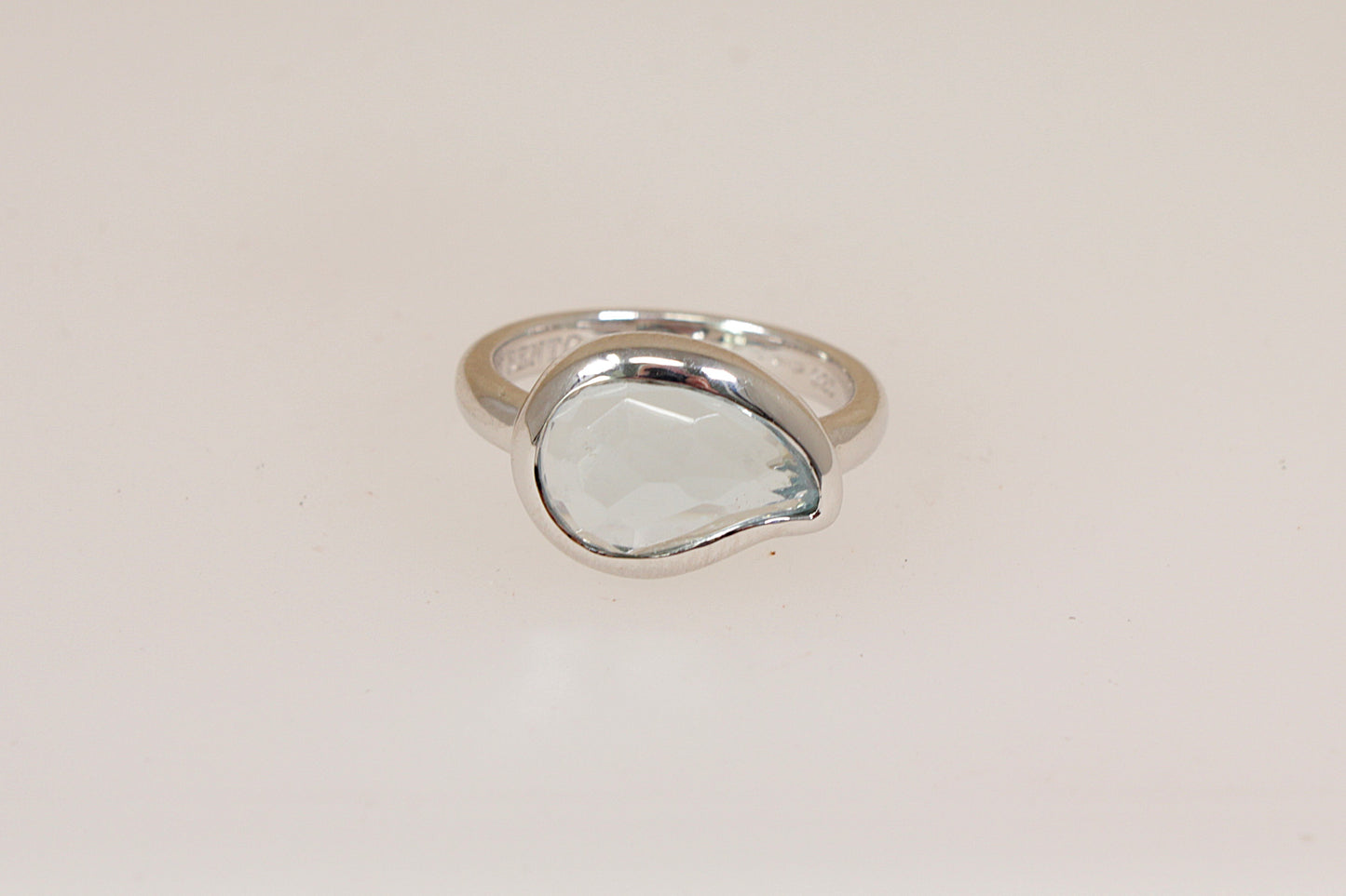 Silver designer ring by Italian maker 'Ti Sento' with a pale blue sem-precious gemstone on a light beige background