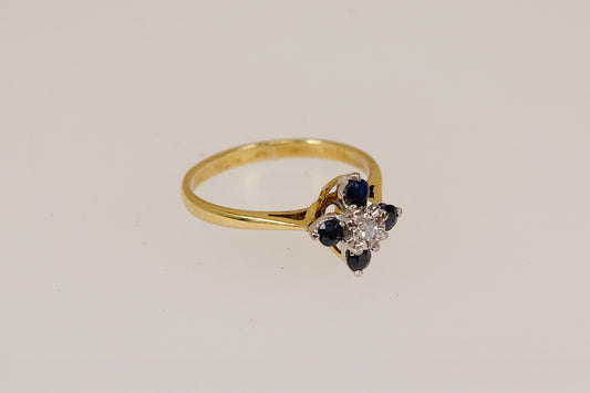 18ct Gold ring with sapphire and diamond design on a beige background