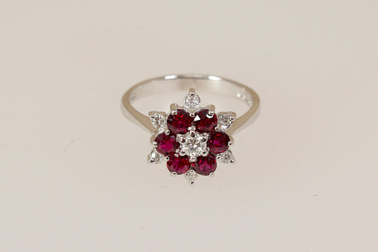 18ct white gold ring with rich red rubies and round brilliant diamond  gemstones on a beige background 
