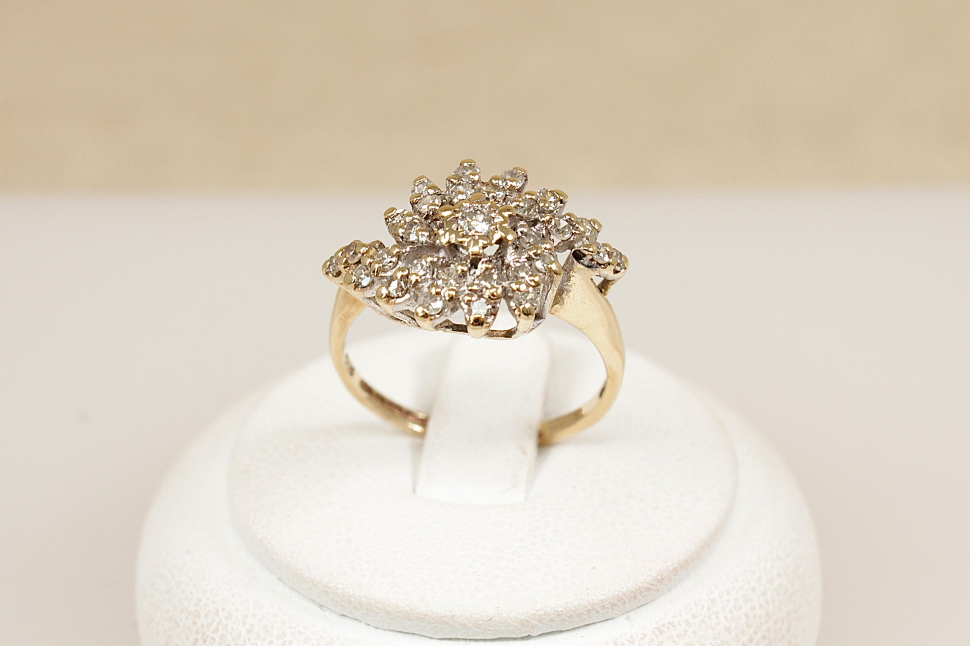 A stylish and bold vintage 9ct yellow Gold Diamond cluster ring. The eye-catching design features a raised basket setting adorned with 29 sparkling round-cut diamonds, centred by a slightly larger diamond. Fully hallmarked inside the band for Birmingham, 1981, confirming 9ct Gold purity and British craftsmanship. UK finger size N.