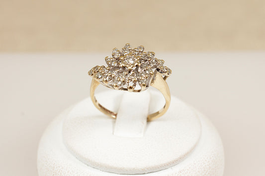 A stylish and bold vintage 9ct yellow Gold Diamond cluster ring. The eye-catching design features a raised basket setting adorned with 29 sparkling round-cut diamonds, centred by a slightly larger diamond. Fully hallmarked inside the band for Birmingham, 1981, confirming 9ct Gold purity and British craftsmanship. UK finger size N.