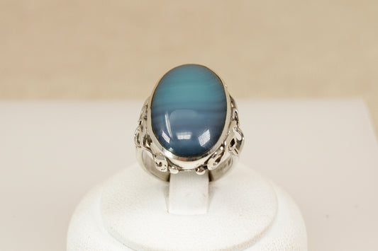 A beautifully crafted sterling silver statement ring, featuring an eye-catching oval cabochon of Blue and Green Banded Agate, Inside the band, the ring bears full Sheffield hallmarks for 1998, UK finger size O.