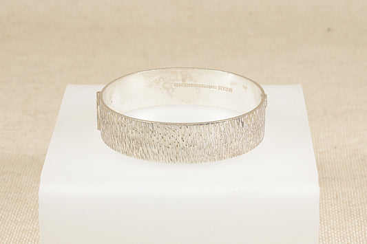 Vintage 1970's solid silver hinged bracelet bangle with bark effect finish.