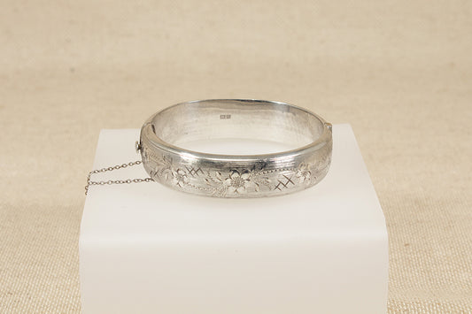 Vintage Antique Silver bracelet bangle  on a white cube with a beige background