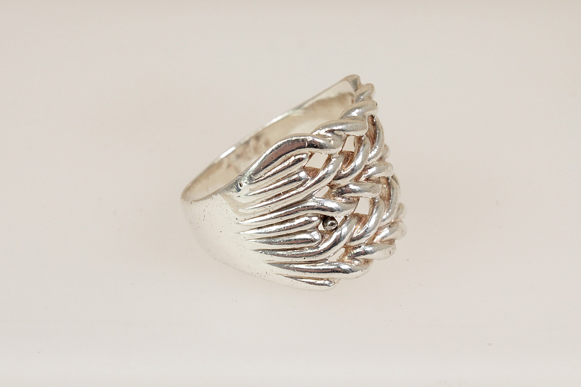 Silver gents keeper ring with a textured design on a light beige background