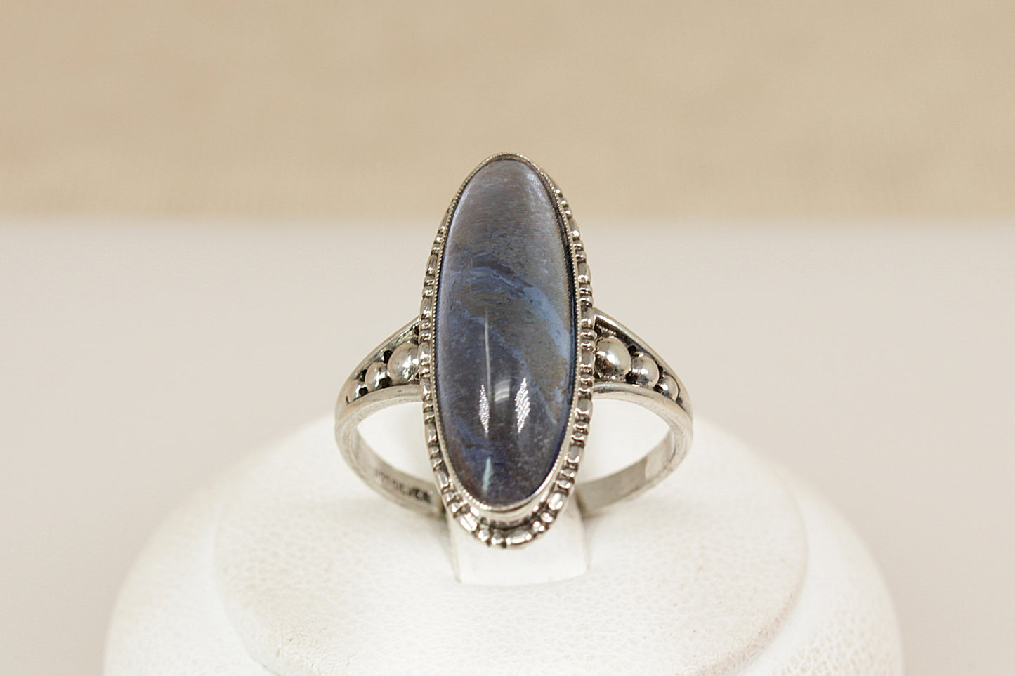 A captivating vintage sterling silver ring, showcasing a striking navette-shaped Labradorite cabochon with a beautifully high domed cut. The stone shimmers with translucent flashes, changing with every movement and catching the light like magic. UK finger size P.