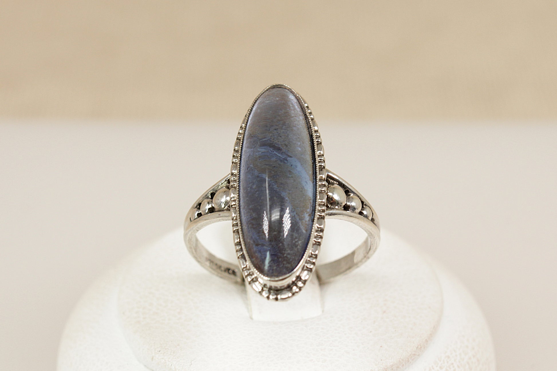 A captivating vintage sterling silver ring, showcasing a striking navette-shaped Labradorite cabochon with a beautifully high domed cut. The stone shimmers with translucent flashes, changing with every movement and catching the light like magic. UK finger size P.