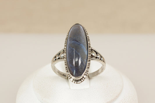A captivating vintage sterling silver ring, showcasing a striking navette-shaped Labradorite cabochon with a beautifully high domed cut. The stone shimmers with translucent flashes, changing with every movement and catching the light like magic. UK finger size P.