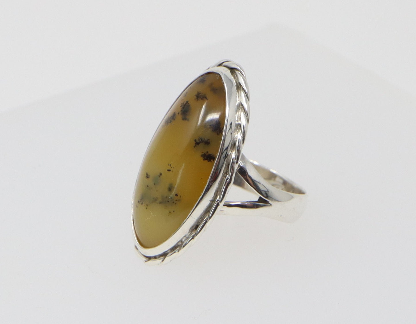 This elegant silver ring is finely made and has a navette shaped piece of Moss Agate set in a beautifully decorated silver setting. Inside the band it is stamped 925 for sterling silver. UK finger size N.
