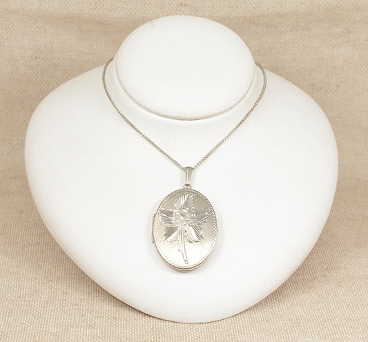 Silver necklace with an oval hinged locket pendant on a white jewelry display
